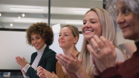 Fila-De-Empresarias-En-Una-Oficina-Moderna-Aplaudiendo-La-Presentación-De-Un-Colega