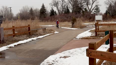 Carrera-De-Invierno-En-Bicicleta-Mientras-Una-Mujer-Pasa-Frente-A-La-Cámara