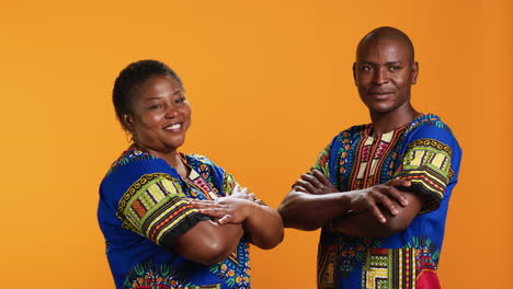 african american couple in traditional attire posing on camera