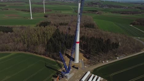 Windmill-Construction-With-Huge-Crane---aerial-drone-shot