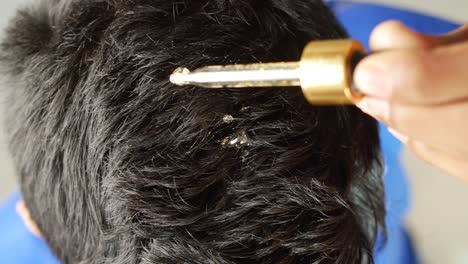 hombres jóvenes aplicando aceites esenciales en su cabello