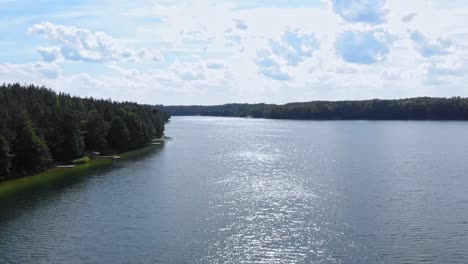 Aguas-Tranquilas-Del-Lago-Estrellas-Del-Lago-Capturadas-Por-Un-Dron-En-El-Molino-De-Borowy,-Voivodato-De-Pomerania,-Polonia