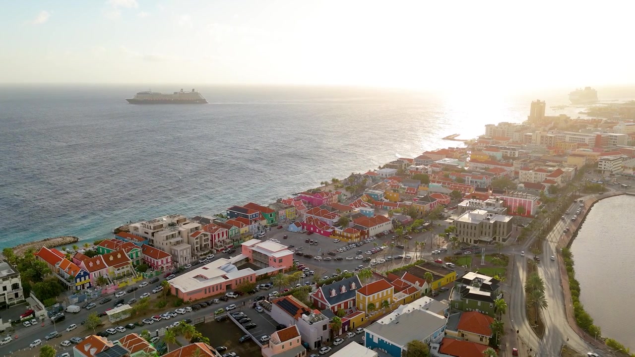 Droneopptak av Pietermaai ved solnedgang, med fargerik UNESCO-arkitektur langs den karibiske kysten.