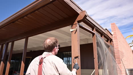 Rear-View-Of-Man-Painting-House---medium-shot