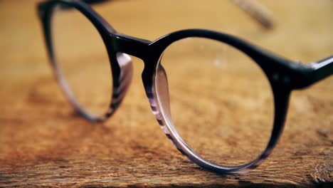 spectacles on wooden table 4k