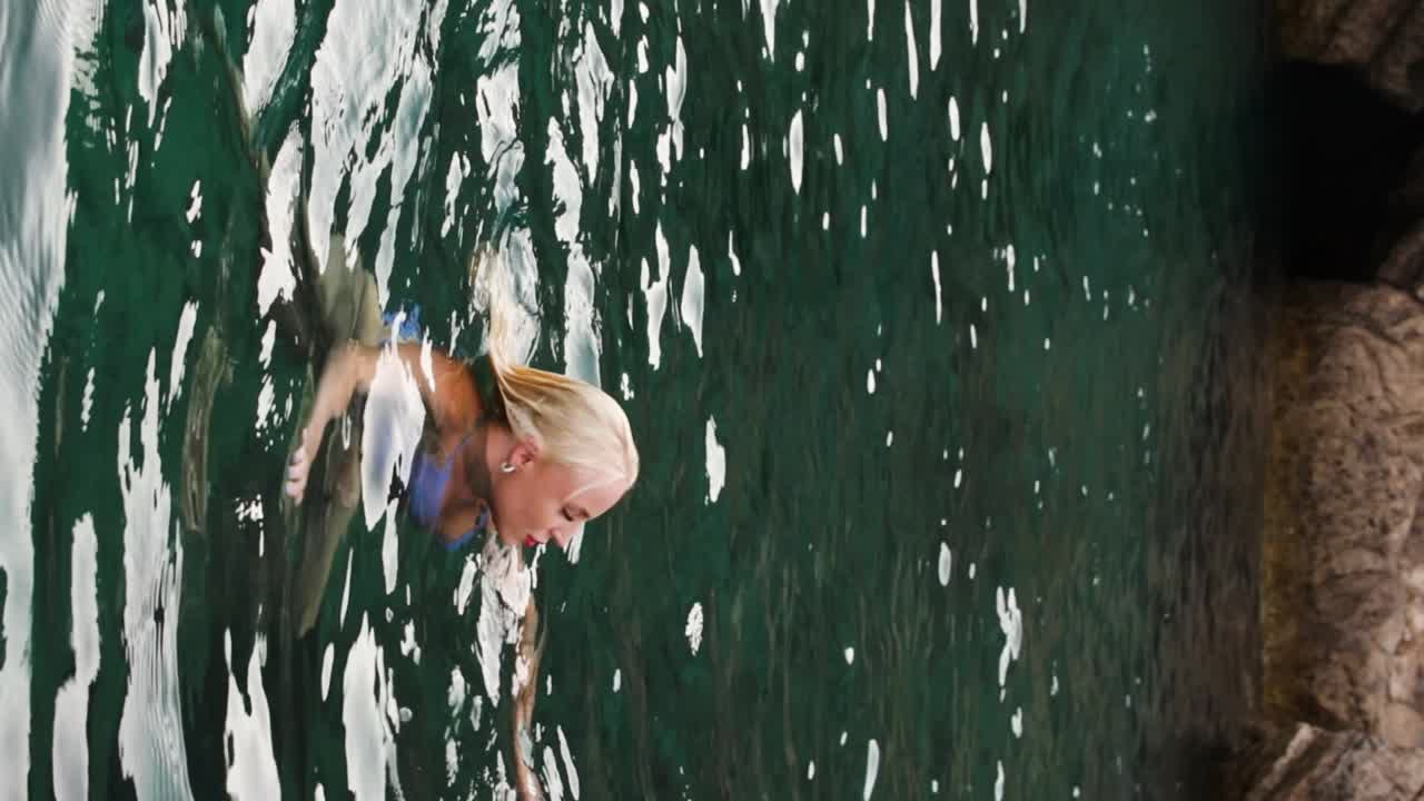 Young blonde girl swims in the Adriatic Sea near Croatia's Blue Cave