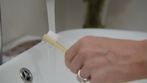 a woman washing tooth brush, close up