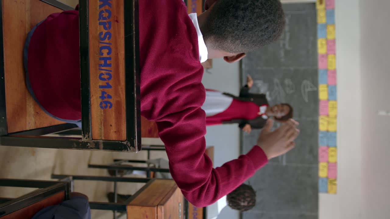 Teacher With Student Raising Hand In Class In African School - Vertical Shot