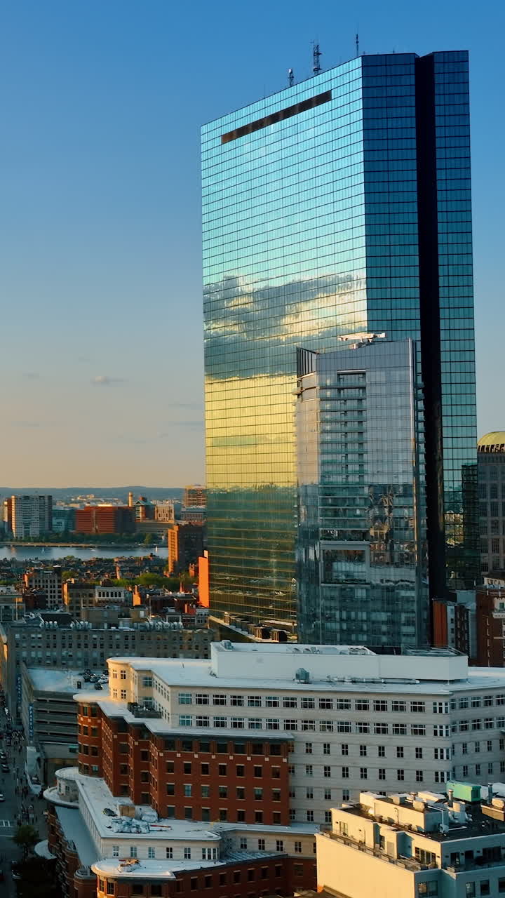 Sun downing sky reflecting in the mirror windows of skyscrapers. Modern urban architecture of Boston, Massachusetts, USA.. Vertical video