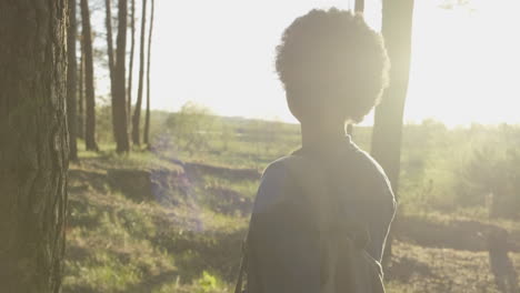 a pretty girl takes a walk in the forest at sunset