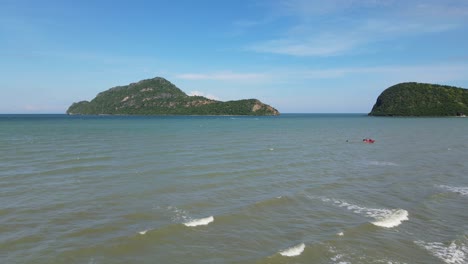 A-rescue-moving-on-the-left-side-dropping-a-man-in-the-water-as-part-the-training,-moving-waves,-lovely-islands,-Rescue-Training,-Dolphin-Bay,-Sam-Roi-Yot-National-Park,-Prachuap-Khiri-Khan,-Thailand