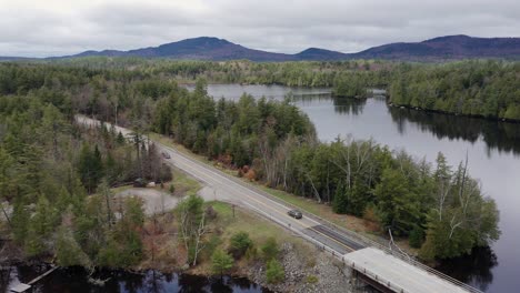 aerial view of vehicles traveling on road over bridge near lake