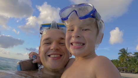 smiling father and son bathing in the sea