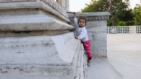 cute-toddler-innocent-expression-at-temple-courtyard-at-day-from-unique-perspective