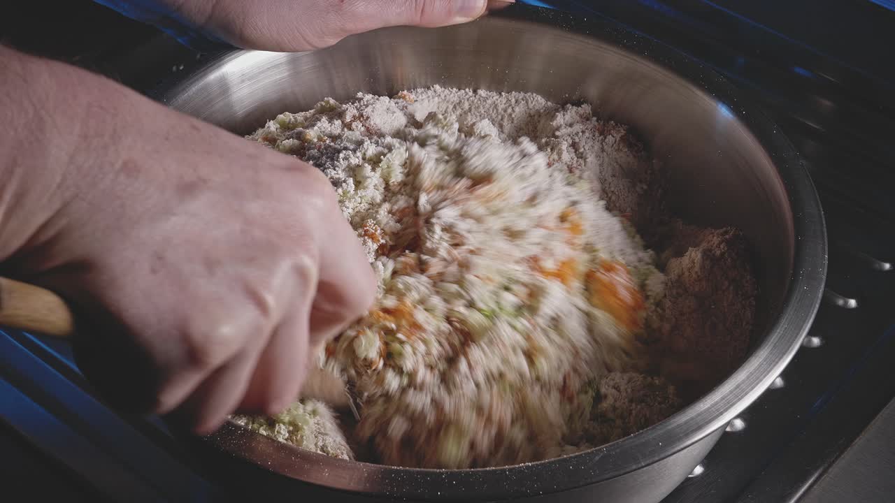 manos mezclando los ingredientes de la barra de bocadillos vegetarianos en un tazón con una cuchara de madera