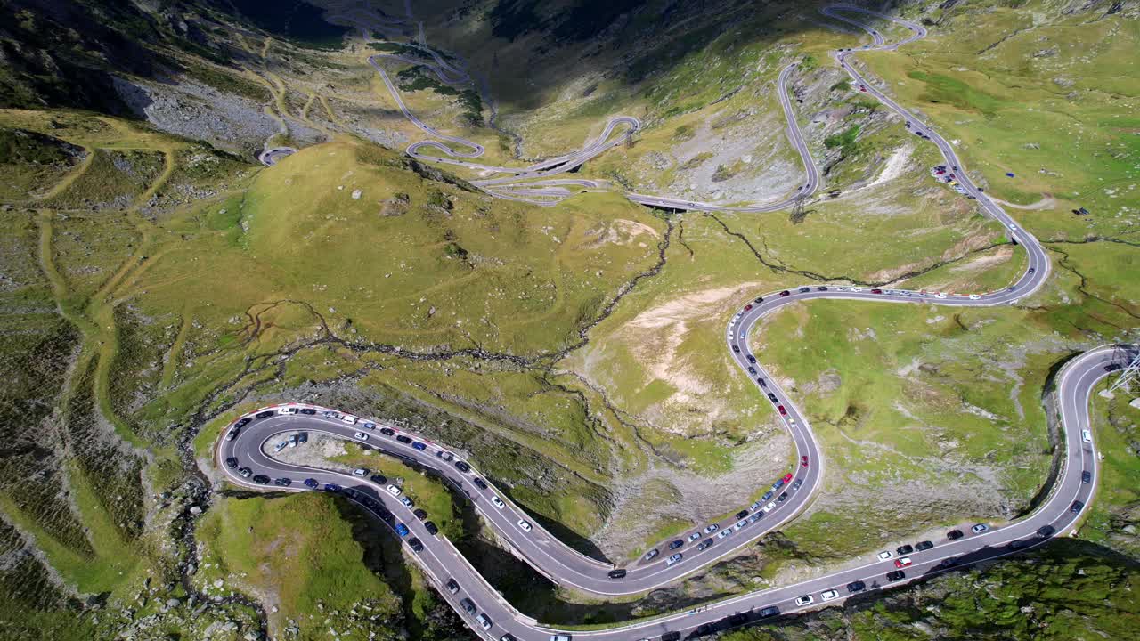 Bird's eye view perspective of cars parked on should of Transfagarasan Serpentine Road romania on switchback section