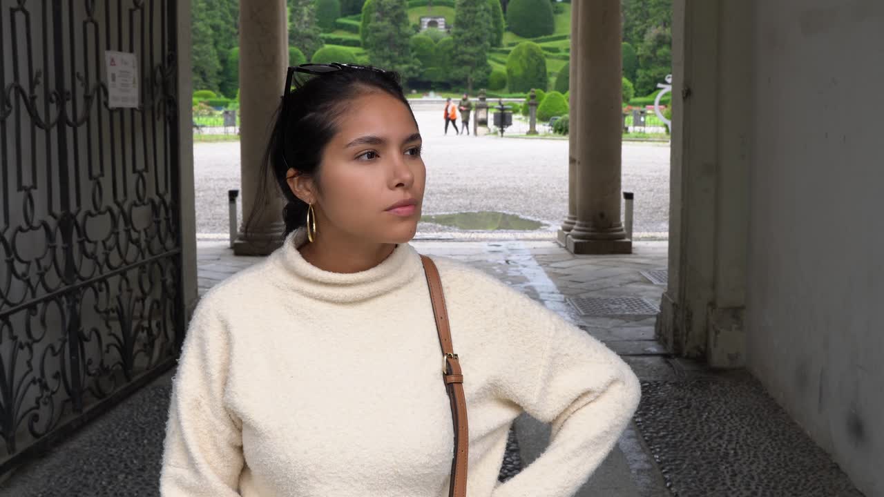 젊고 아름다운 여자가 누군가를 기다리고 있습니다.