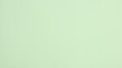 una pila de utensilios de cocina ecológicos y sin residuos aparece sobre un fondo verde claro.