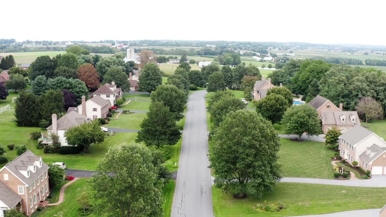 Reverse aerial reveals traditional American large suburban homes in USA development neighborhood