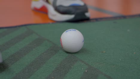 Slowmotion-closeup-shot-of-a-golf-ball-being-hit-in-a-game-of-minigolf