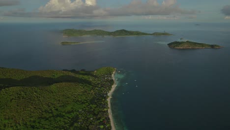 aerial view of lush green islands surrounded by clear blue waters in the philippines, showcasing tropical beauty and remote tranquility. perfect for travel, nature, and coastal scenes.