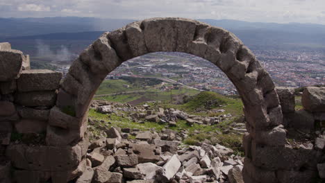 stone arch overlooking a city landscape in pergamum