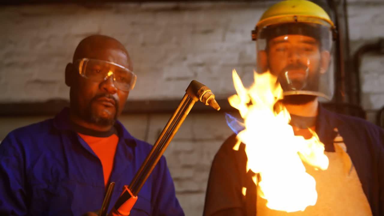 Metalsmith lighting welding torch in workshop 4k