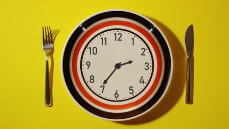 timelapse clock on the plate on the table with the cutlery