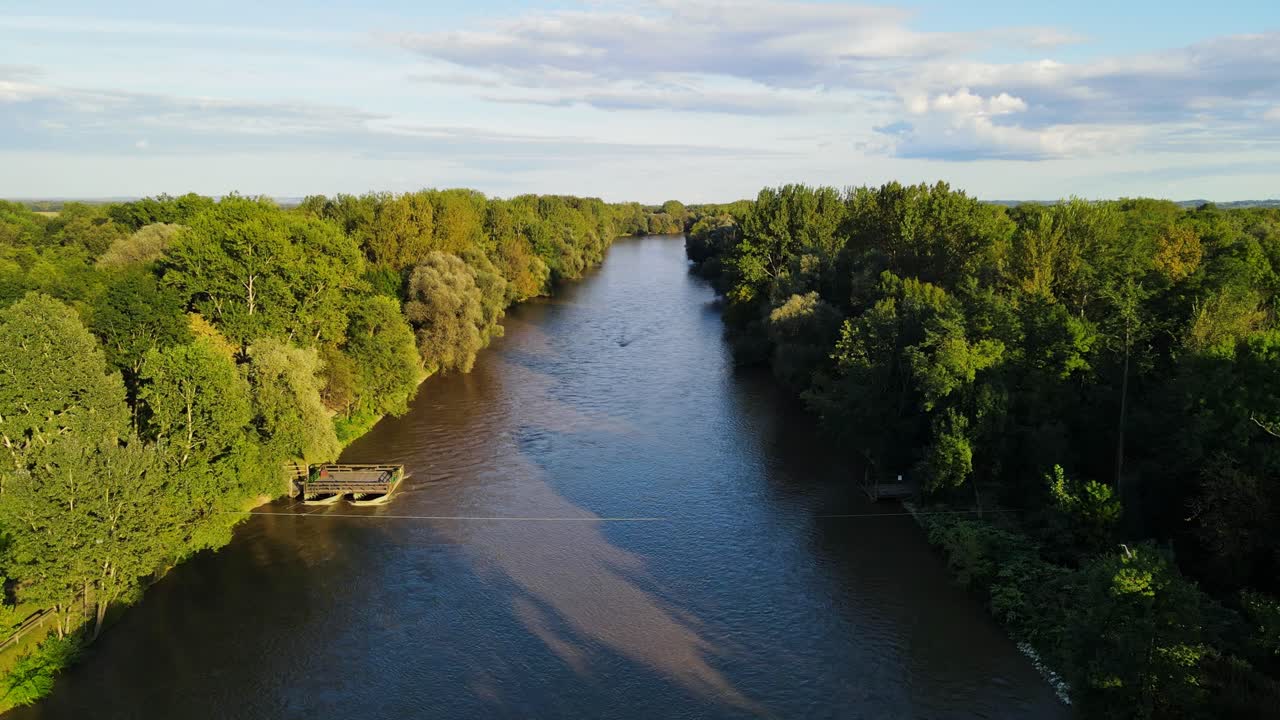 Voo baixo de drone sobre o Rio Mura, que atravessa densa mata ciliar e floresta de várzea na Eslovênia.
