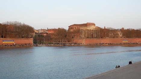 panning view of pont neuf bridge, notre dame de la daurade basilica and garonne river banks in toulouse, france