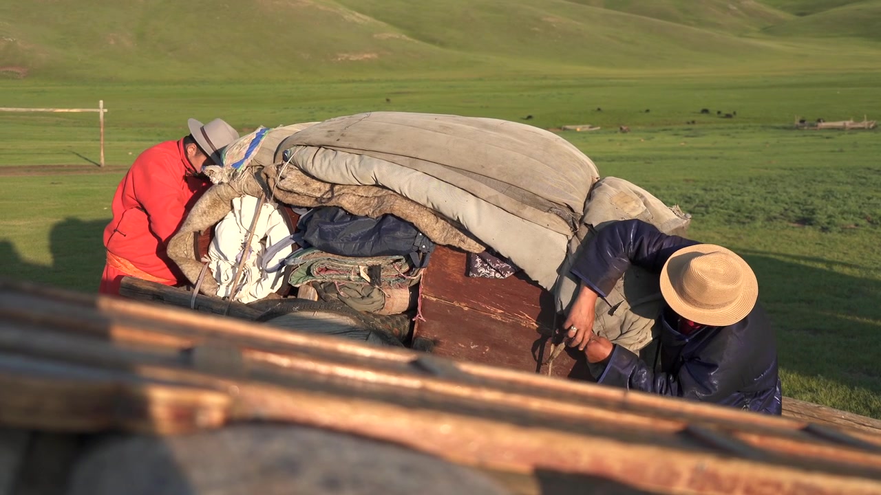 Mongolian Nomads Packing Belongings on a Cart in the Steppe