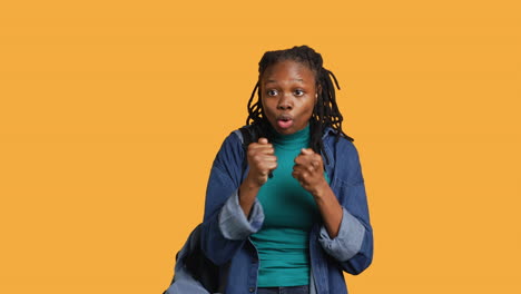 Woman-jokingly-pretending-to-fight-with-friend,-studio-background