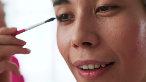 asian person using makeup at home