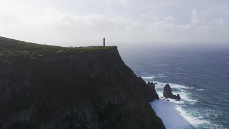 drone-footage-of-a-Lighthouse-on-the-edge-of-dramatic-cliffs-with-the-Atlantic-Ocean-in-the-background,-São-Jorge-island,-the-Azores,-Portugal