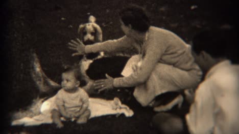 1936: mom blocking protecting baby from fighting dogs outdoor picnic.