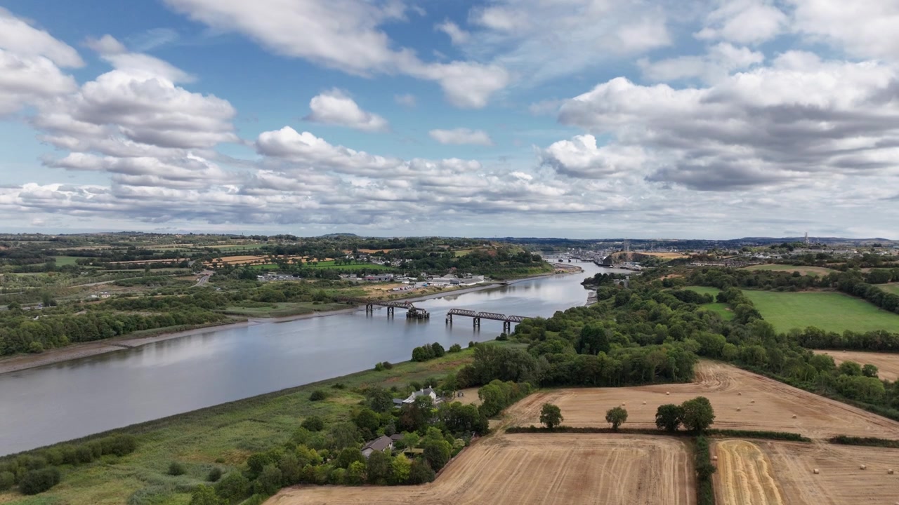 Incredibile ripresa aerea con drone in Irlanda che mostra terreni agricoli accanto al ponte ferroviario in disuso sul fiume Suir e la città di Waterford sullo sfondo