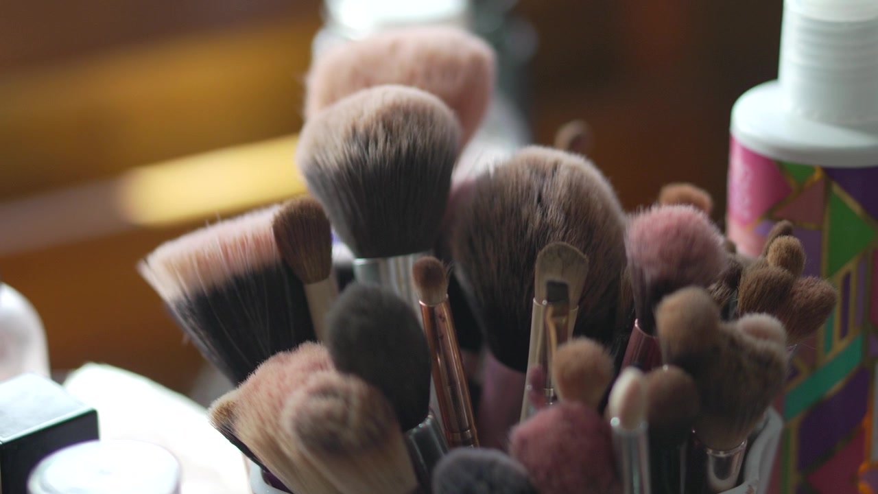 Primo piano di eleganti pennelli da trucco assortiti in un supporto. Strumenti di bellezza professionali e cosmetici