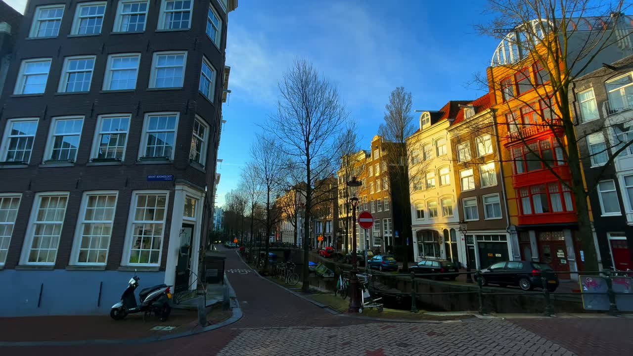 calle vacía de ámsterdam con canal y casas en invierno con luz solar