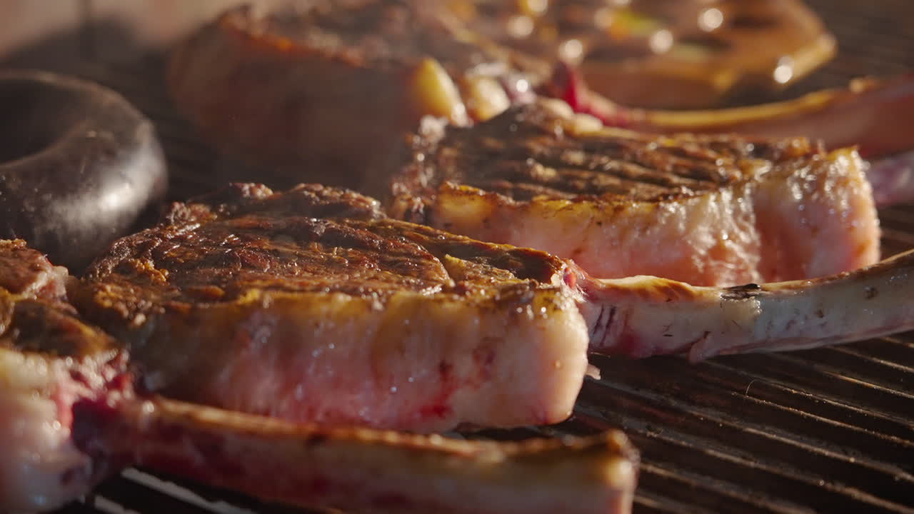 Primo piano di deliziose bistecche e salsicce che grigliano su un barbecue