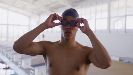 Swimmer-taking-off-his-pool-goggles-and-looking-at-camera