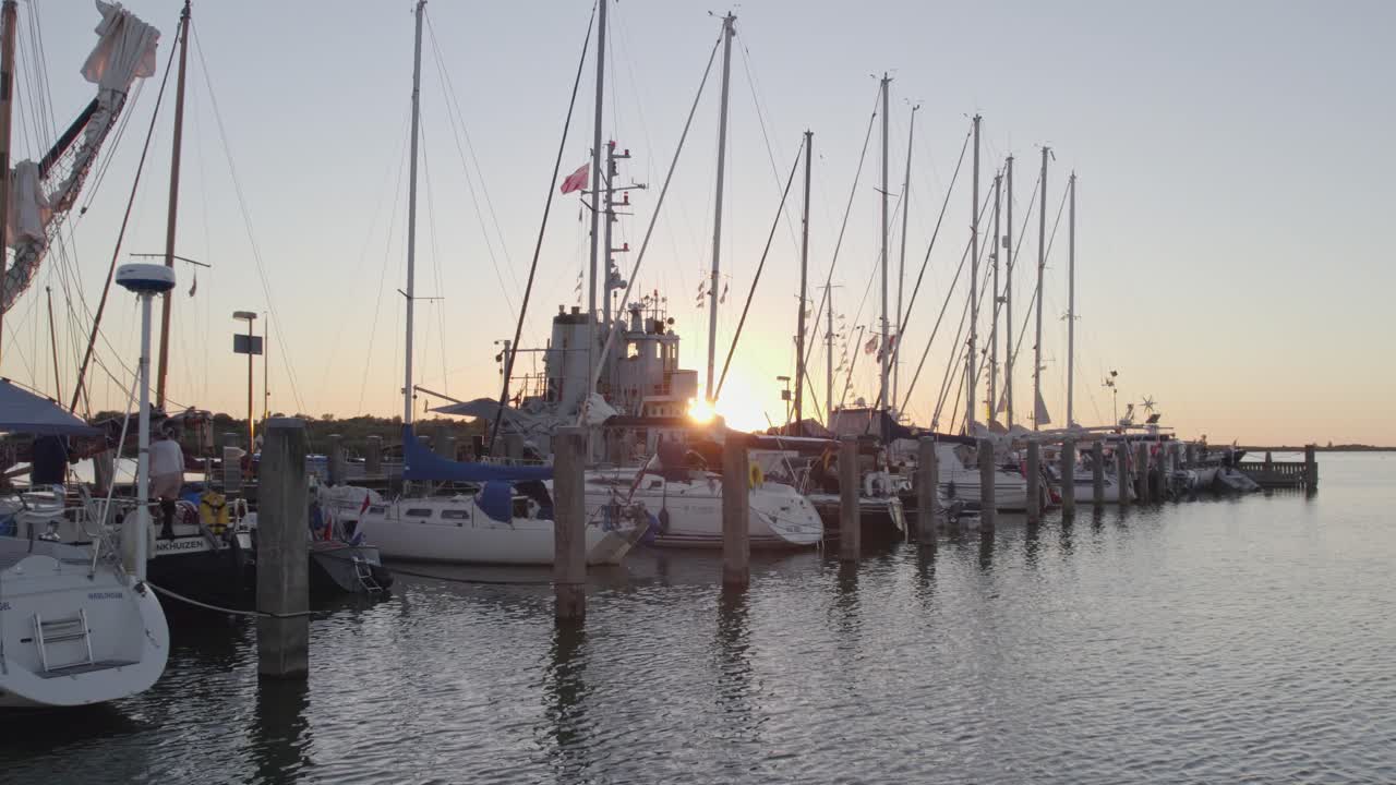 Sailing boats docked in the harbour of Makkum Friesland during sunset, aerial