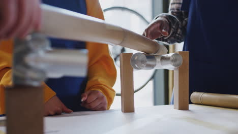 close up of multi-cultural team in workshop assembling hand built sustainable bamboo bicycle frame