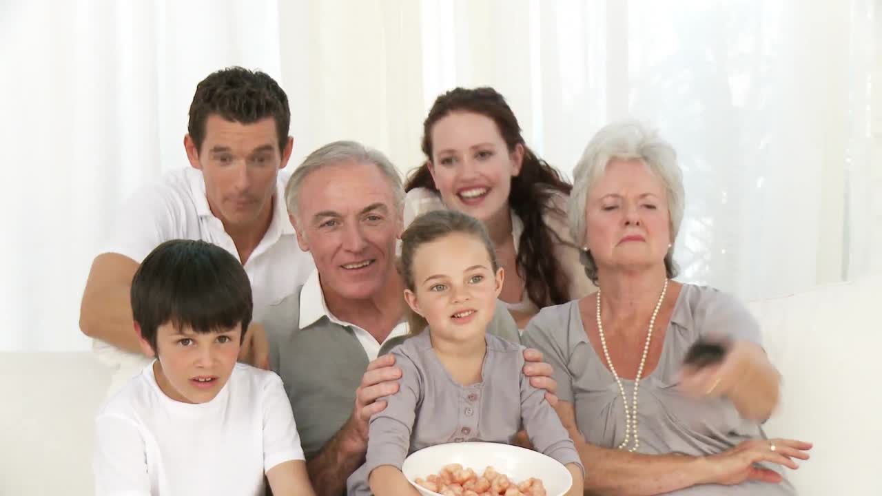 가족들이  ⁇ 을 먹고 텔레비전을 보고 있습니다.