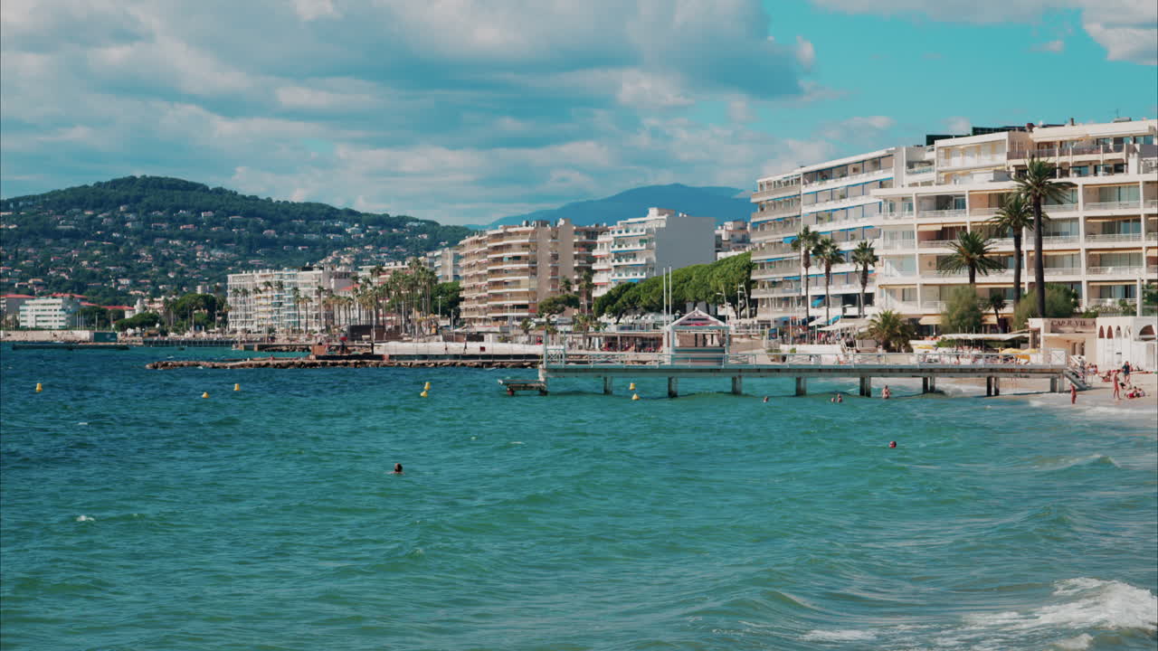 Persone che nuotano nel mare e si rilassano sulla spiaggia di Antibes, Francia