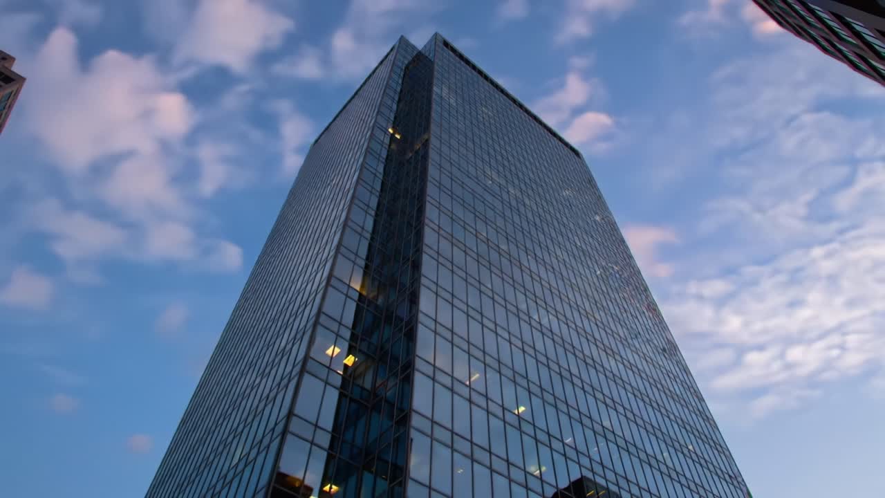 A Stunning View of a Modern Skyscraper Against a Beautiful Sunset Sky, Showcasing Reflections on Glass and the Architectural Grandeur of Urban Spaces