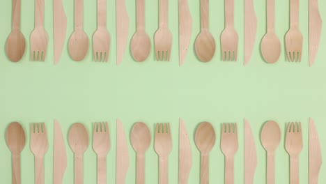 eco friendly zero waste eating utensil made of bamboo wood on two sides of green theme. stop motion