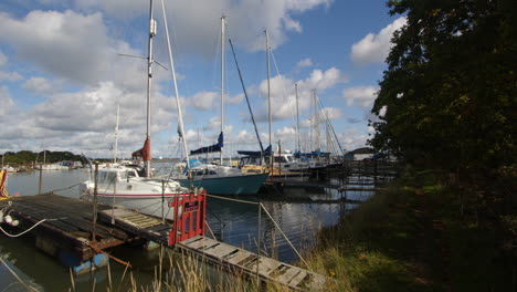 sailboats moored up at high tide at ashlett creek sailing club in the solent, southampton