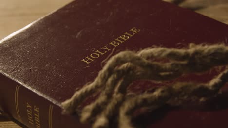 religious concept shot of old bible on wooden table with rope 2