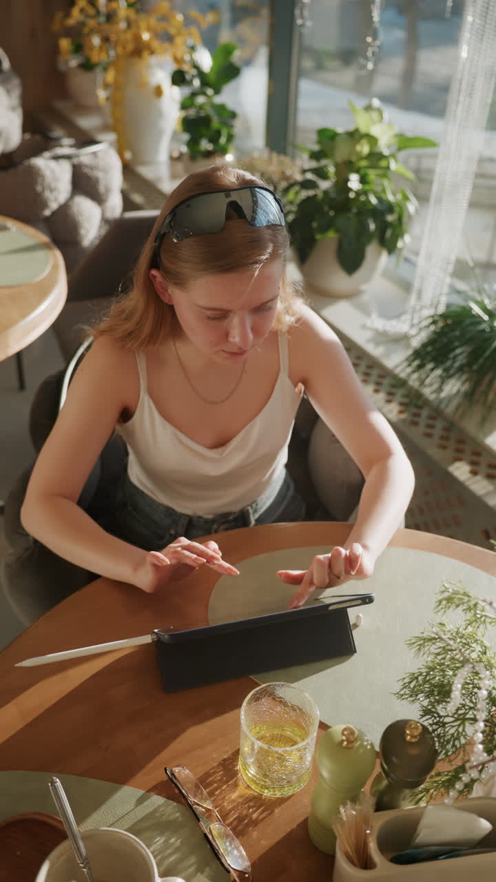 Donna stressata che lavora. Lavoratrice sotto pressione alla scrivania. Donna ansiosa che usa il tablet tra lo stress lavorativo. Donna bianca con occhiali da sole che prova tensione durante una sessione di lavoro a distanza.
