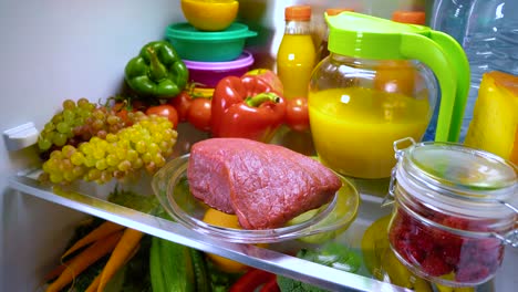 Fresh-raw-meat-on-a-shelf-open-refrigerator